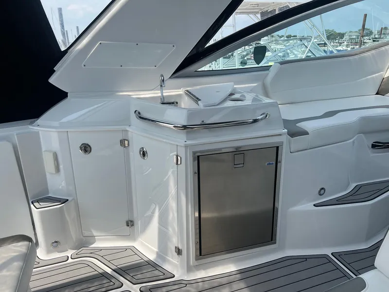 Slide: The Image of 2019 Monterey 295 Sport Yacht interior with sink and mini fridge. - 9