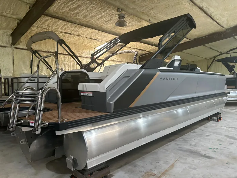 Slide: The Image of 2023 Manitou 26 Explore Switchback pontoon boat with trifold bench in storage. - 1