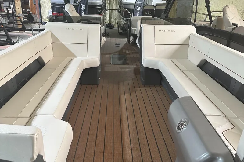 Slide: The Image of 2023 Manitou 26 Explore Switchback pontoon boat with trifold bench seating and wooden deck. - 2