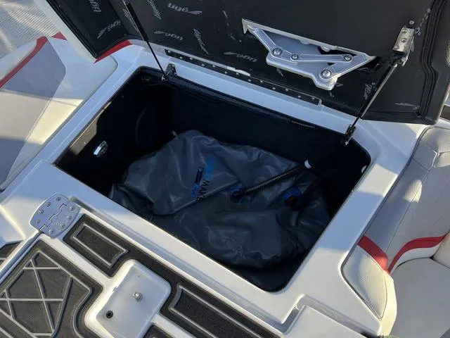 Slide: The Image of 2022 Tigé 23ZX boat storage compartment with open lid and equipment inside. - 14