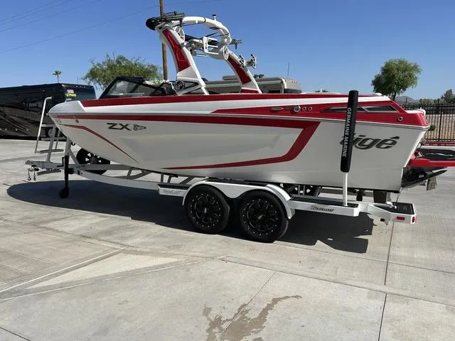 Slide: The Image of 2022 Tigé 23ZX boat on a trailer, white with red accents. - 4