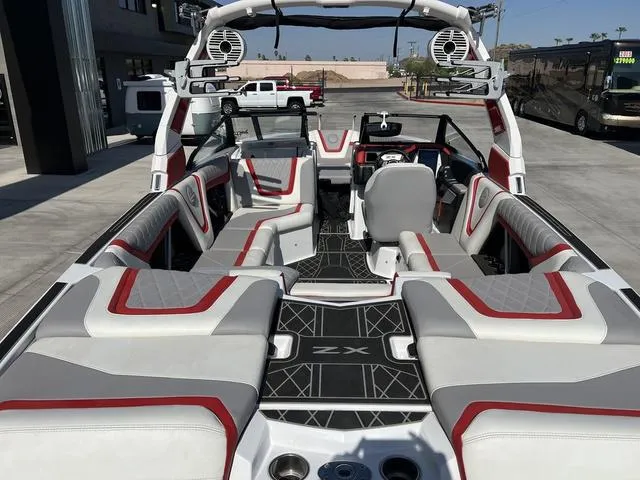 Slide: The Image of 2022 Tigé 23ZX boat interior with red and gray seating, advanced sound system. - 8