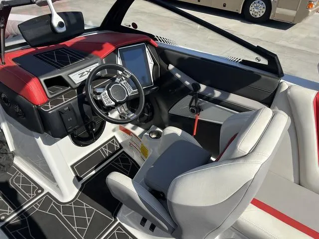 Slide: The Image of 2022 Tigé 23ZX boat cockpit with modern steering wheel and touchscreen controls. - 9
