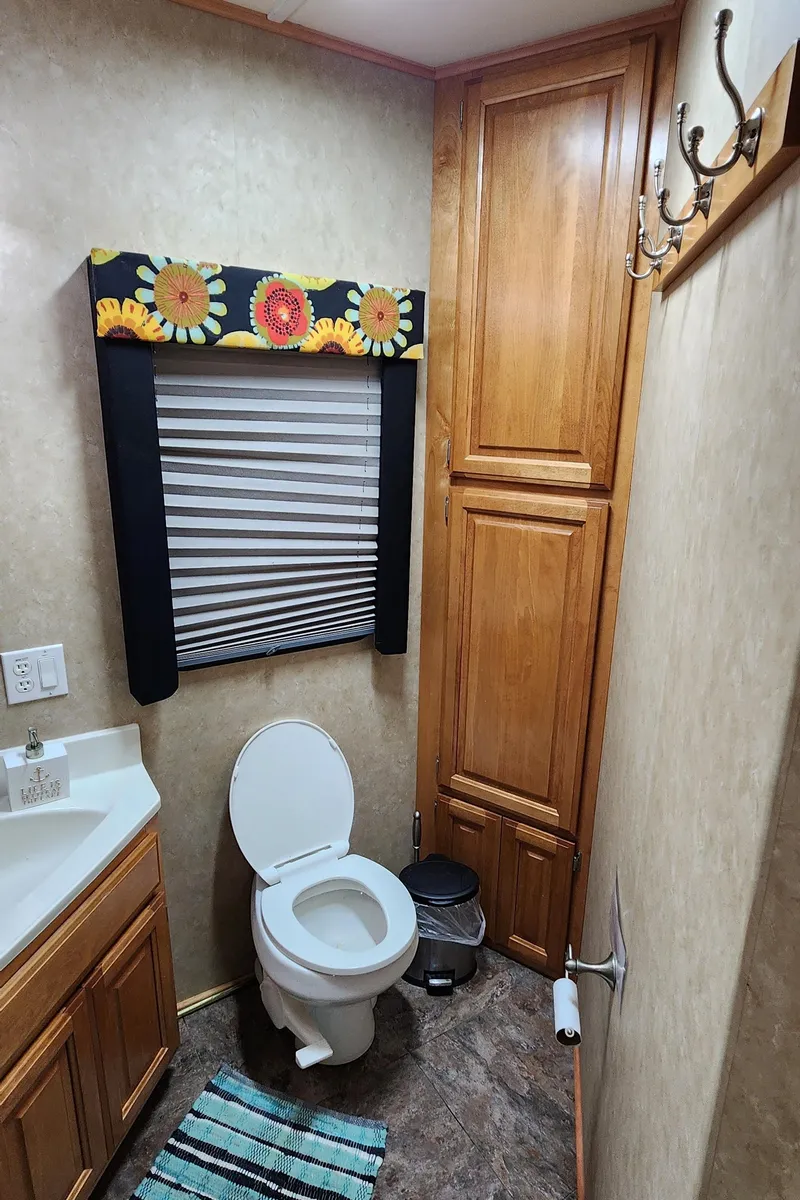 Slide: The Image of Bathroom in a 2007 Destination Yachts 16x58 houseboat with wooden cabinets and floral window valance. - 30