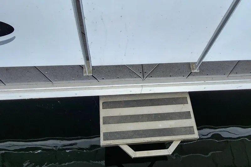 Slide: The Image of Boarding ladder of 2007 Destination Yachts 16x58 houseboat over water. - 7