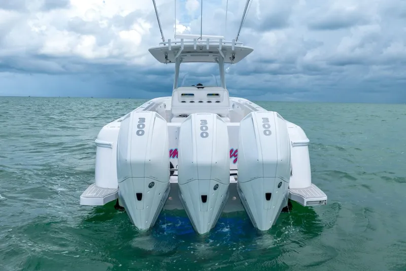 Slide: The Image of 2022 Intrepid 375 Nomad FE boat with triple outboard engines on the water. - 15