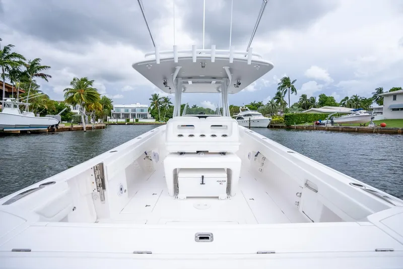 Slide: The Image of 2022 Intrepid 375 Nomad FE boat on a calm waterway with palm trees. - 20