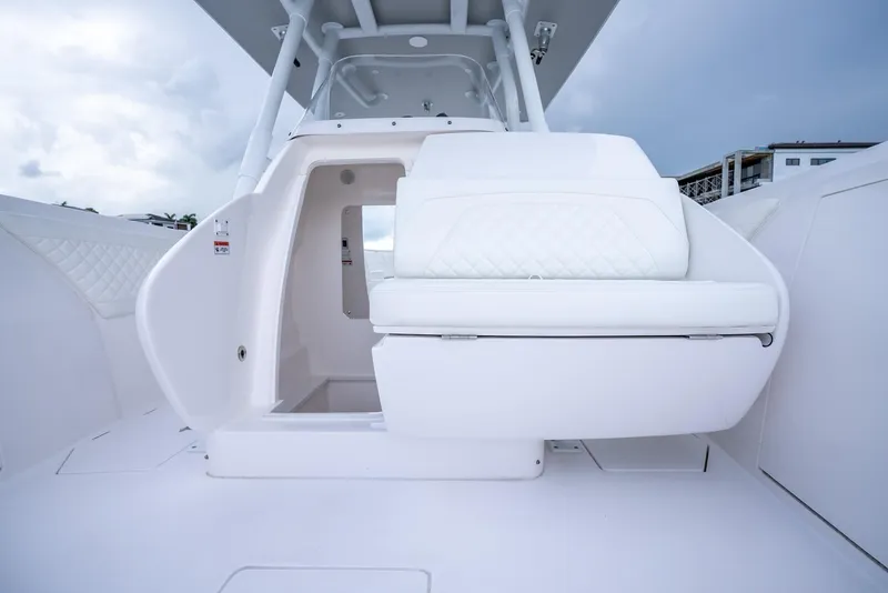Slide: The Image of 2022 Intrepid 375 Nomad FE boat interior with white seating and cabin entrance. - 28