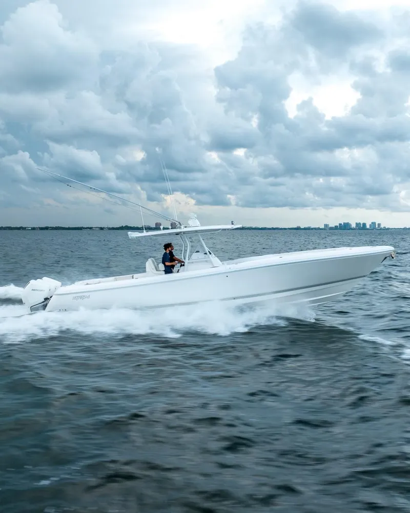 Slide: The Image of 2022 Intrepid 375 Nomad FE boat cruising on open water under cloudy skies. - 3