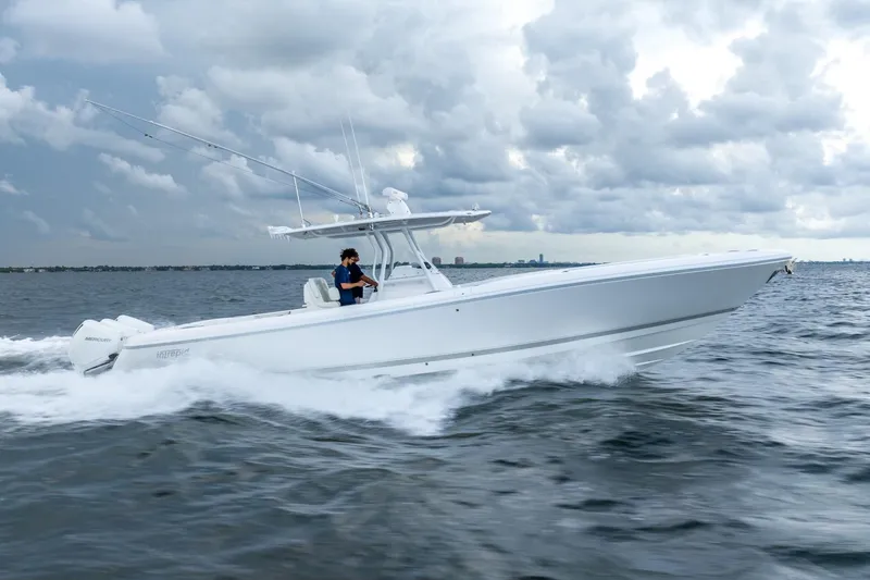 Slide: The Image of 2022 Intrepid 375 Nomad FE boat cruising on open water under cloudy skies. - 4