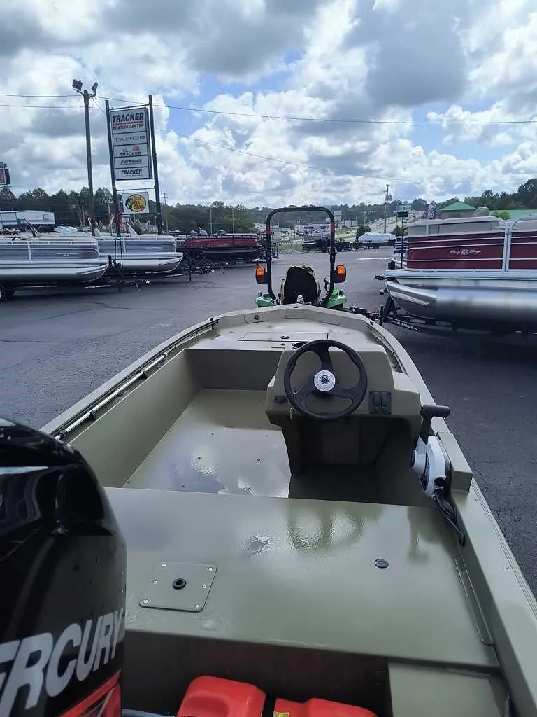 Slide: The Image of 2024 Tracker Grizzly 1648 SC boat displayed at a dealership. - 2