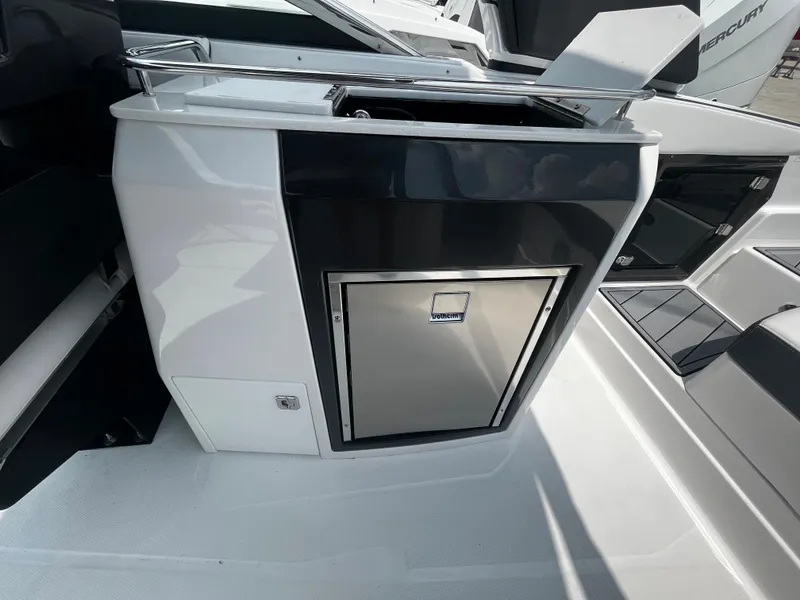 Slide: The Image of 2024 Monterey 275 Super Sport boat interior with built-in stainless steel refrigerator. - 14
