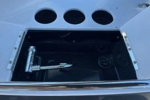 Slide: The Image of 2024 Monterey 275 Super Sport boat compartment with chrome fittings and cup holders. - 32