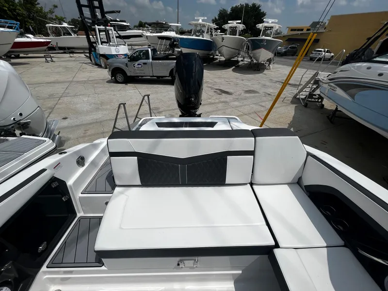 Slide: The Image of 2024 Monterey 275 Super Sport boat with white and black seating in a marina. - 9