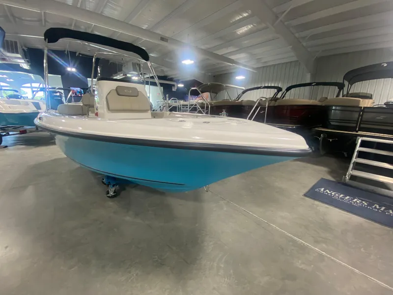 Slide: The Image of 2024 Key West 189 FS boat in showroom, blue hull, white deck, and black canopy. - 3