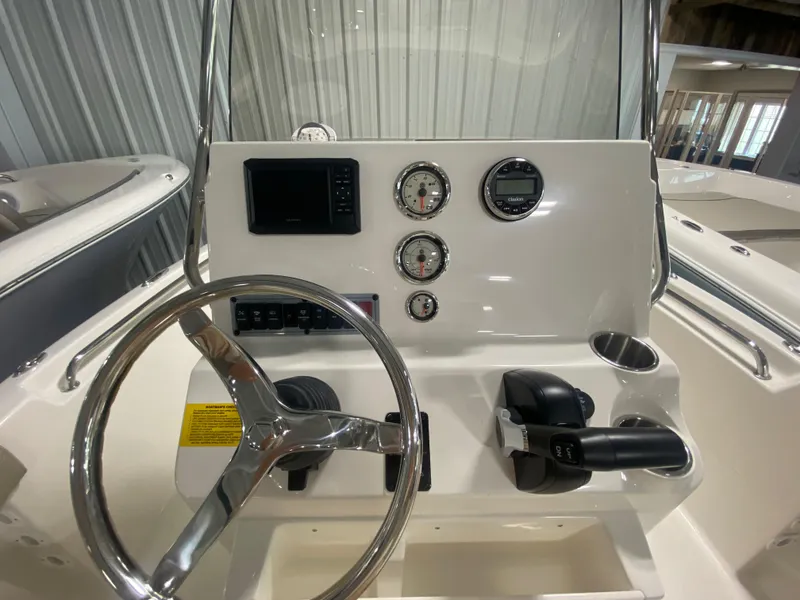 Slide: The Image of 2024 Key West 189 FS boat console with steering wheel, gauges, and controls. - 13