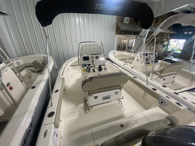 Slide: The Image of 2024 Key West 189 FS boat interior with console and seating, displayed indoors. - 6