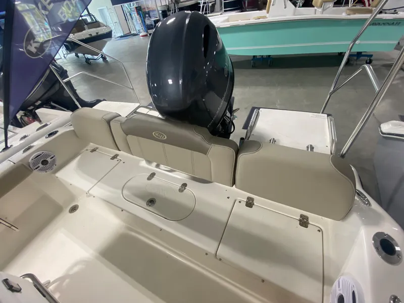 Slide: The Image of 2024 Key West 189 FS boat with outboard motor, beige seating, and storage compartments. - 7