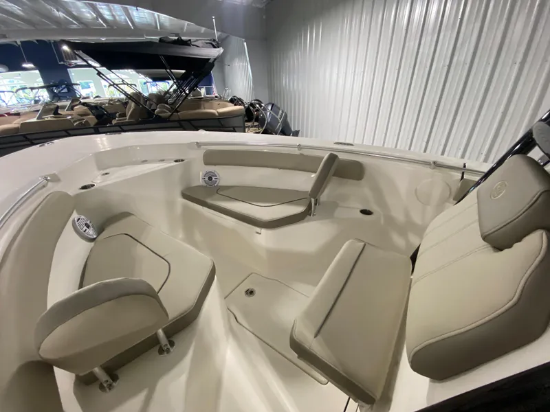 Slide: The Image of 2024 Key West 244 CC boat interior with beige seating in a showroom. - 19