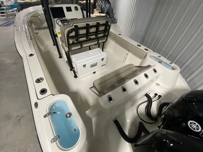 Slide: The Image of 2024 Key West 244 CC boat interior with seating, storage, and dual outboard engines. - 6