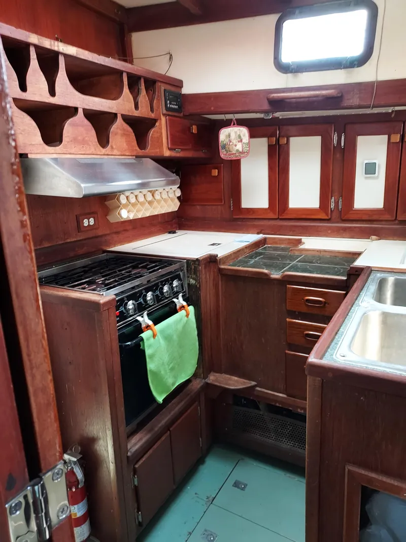 Slide: The Image of 1973 Skookum Ketch kitchen with wooden cabinetry and modern appliances. - 16