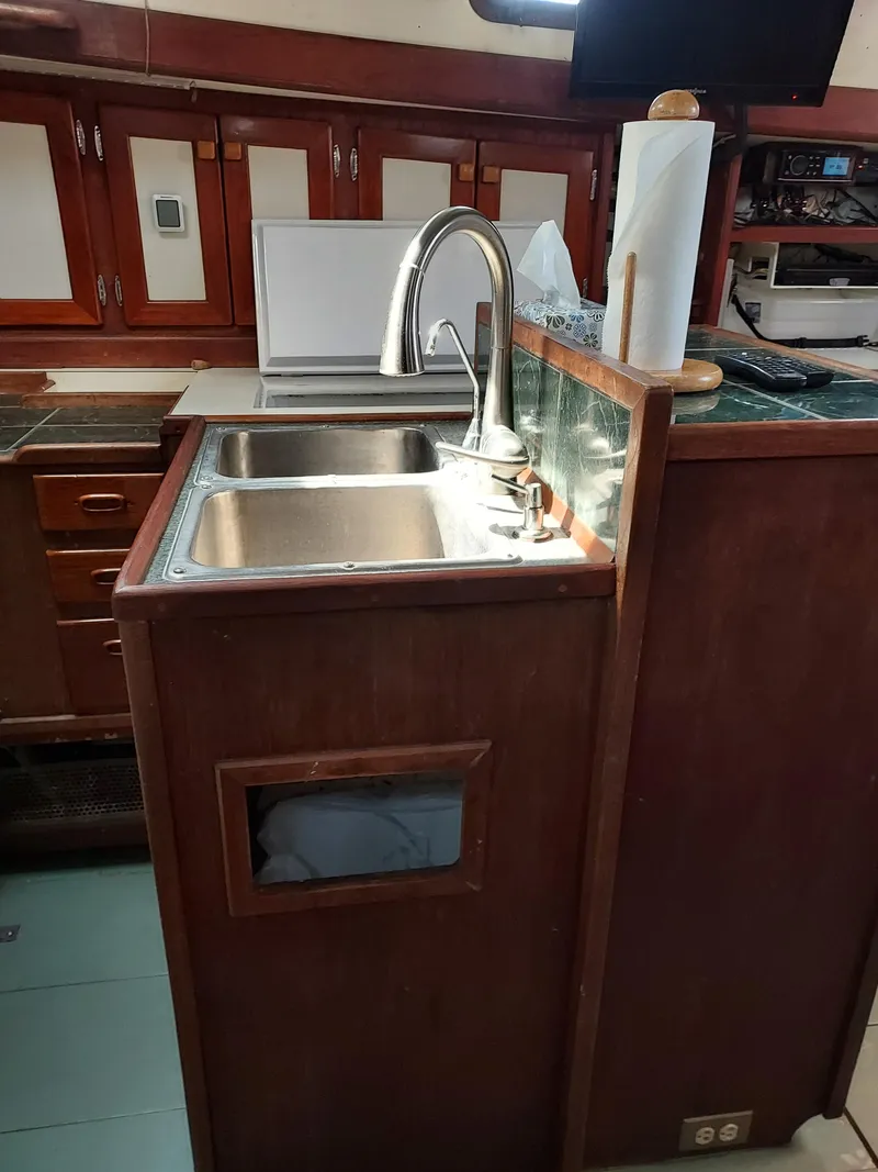 Slide: The Image of 1973 Skookum Ketch kitchen with wooden cabinetry and stainless steel sink. - 21