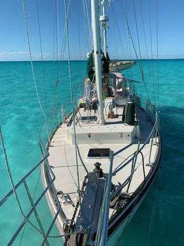 Slide: The Image of 1973 Skookum Ketch sailboat on clear turquoise water, viewed from the deck. - 3