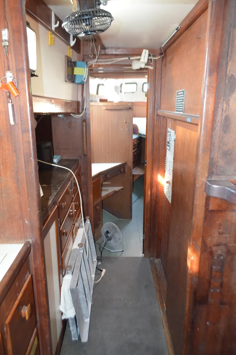Slide: The Image of Interior of a 1973 Skookum Ketch sailboat with wooden cabinetry and compact layout. - 33