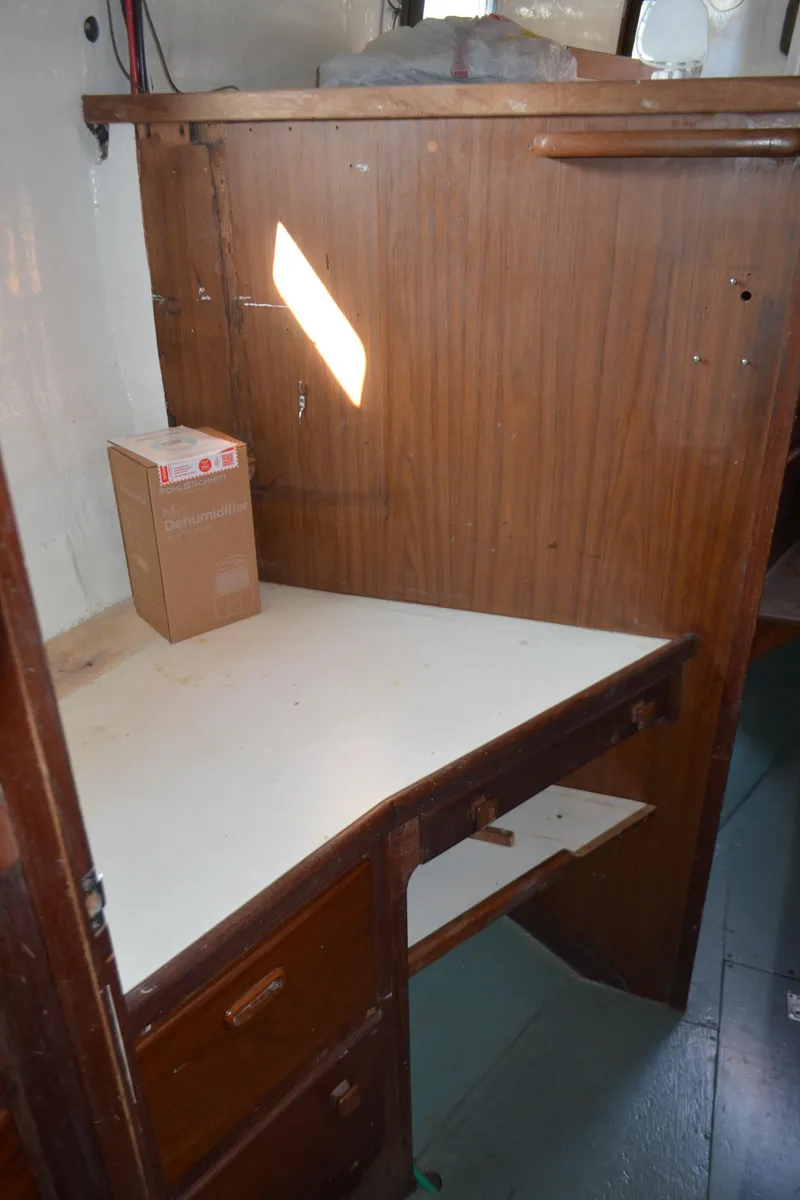 Slide: The Image of 1973 Skookum Ketch interior with wooden desk and storage drawers. - 39