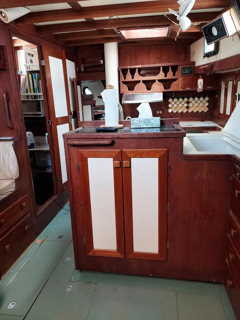 Slide: The Image of Interior of a 1973 Skookum Ketch sailboat with wooden cabinetry and nautical decor. - 7