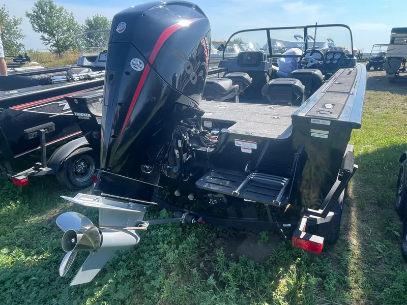 Slide: The Image of 2021 Tracker Targa V-19 WT boat with outboard motor, parked on grass. - 2