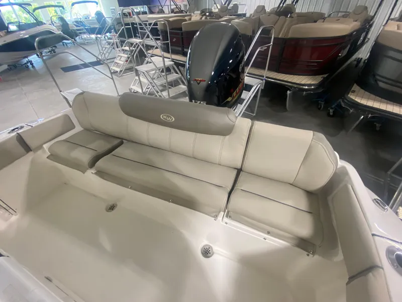 Slide: The Image of 2024 Key West 219 FS boat interior with cushioned seating and outboard motor. - 5