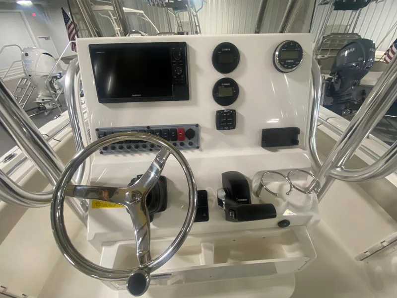 Slide: The Image of 2024 Key West 219 FS boat console with steering wheel, gauges, and navigation screen. - 11