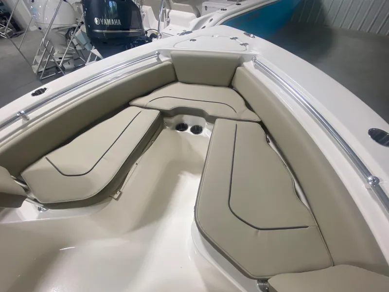 Slide: The Image of 2024 Key West 219 FS boat with cushioned seating and Yamaha engine in showroom. - 18