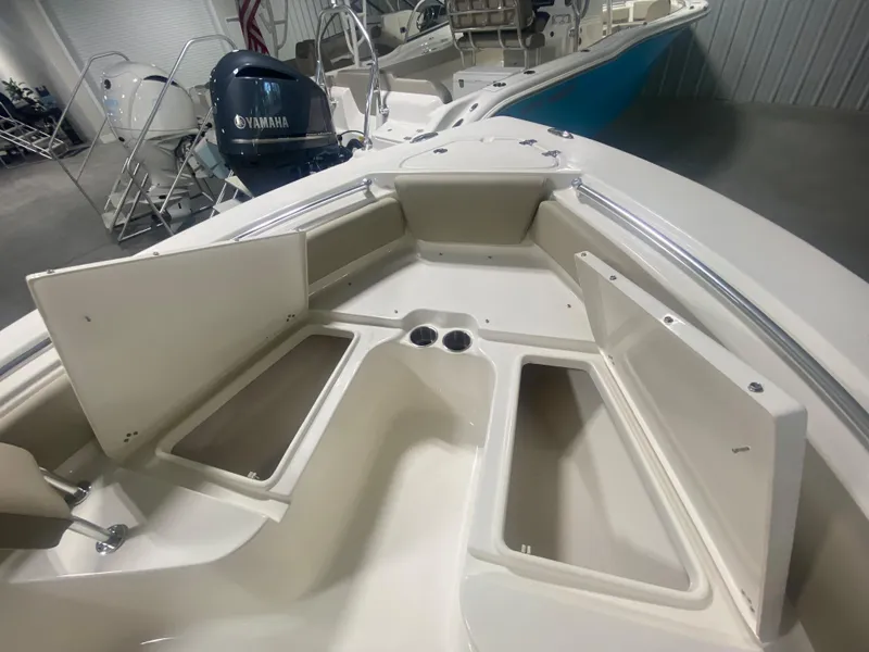 Slide: The Image of 2024 Key West 219 FS boat interior with open storage compartments and Yamaha engine. - 19