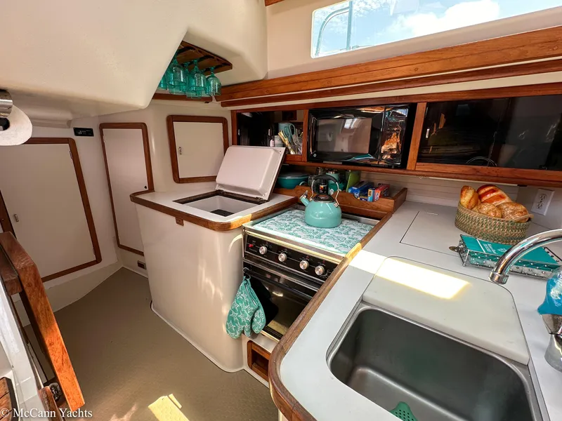 Slide: The Image of Interior of 1991 Catalina 42 yacht kitchen with stove, sink, and wooden cabinetry. - 11