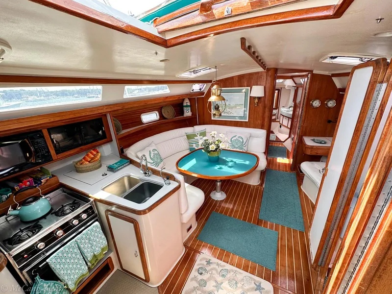 Slide: The Image of Interior of a 1991 Catalina 42 sailboat with cozy dining and kitchen area. - 12