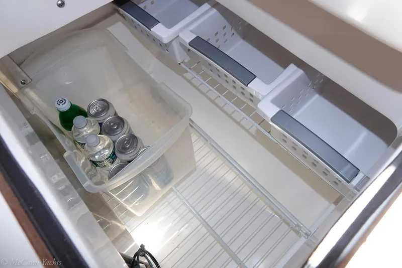 Slide: The Image of Refrigerator interior of 1991 Catalina 42 yacht with drinks in a plastic container. - 14