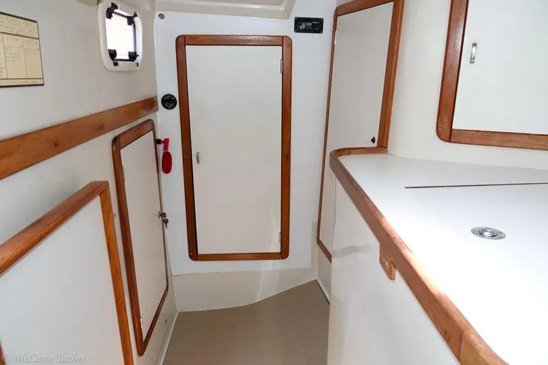 Slide: The Image of Interior of a 1991 Catalina 42 sailboat, featuring wooden trim and white cabinetry. - 15