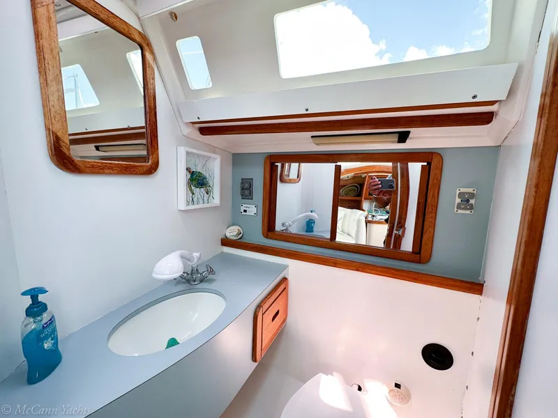 Slide: The Image of Bathroom interior of a 1991 Catalina 42 sailboat, featuring a sink and mirrors. - 24