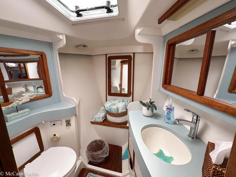 Slide: The Image of Bathroom interior of a 1991 Catalina 42 yacht, featuring a sink, toilet, and mirror. - 34