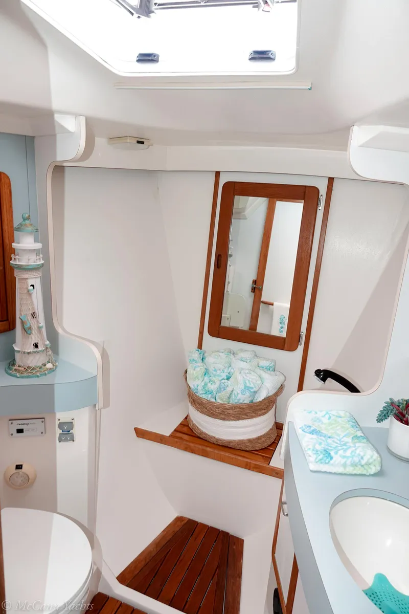 Slide: The Image of 1991 Catalina 42 yacht bathroom with skylight, wooden accents, and nautical decor. - 35