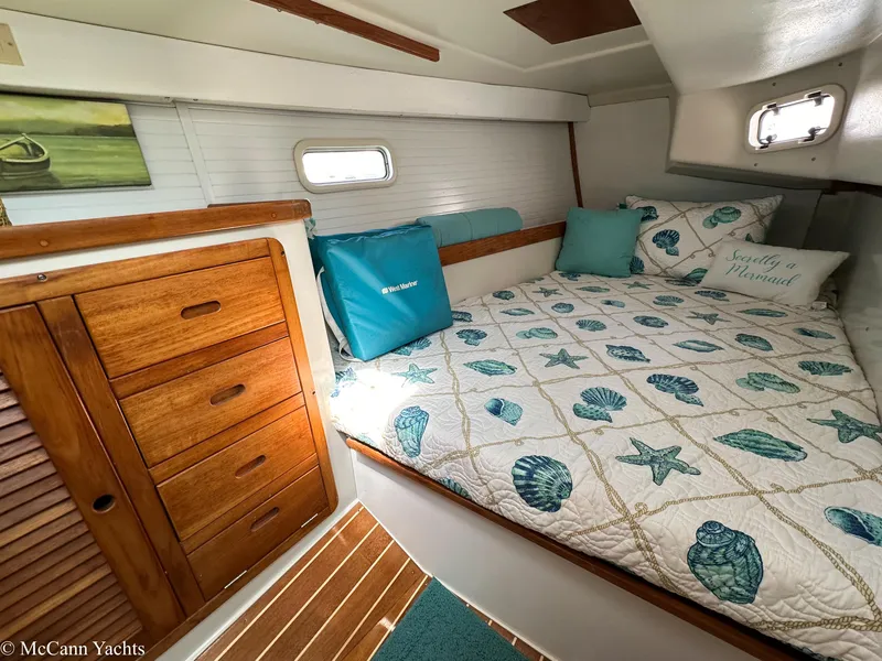 Slide: The Image of Cozy cabin interior of 1991 Catalina 42 yacht with nautical-themed bedding and wooden cabinetry. - 37