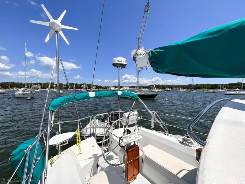 Slide: The Image of Sailboat Catalina 42, 1991 model, anchored in a scenic bay with clear skies. - 4