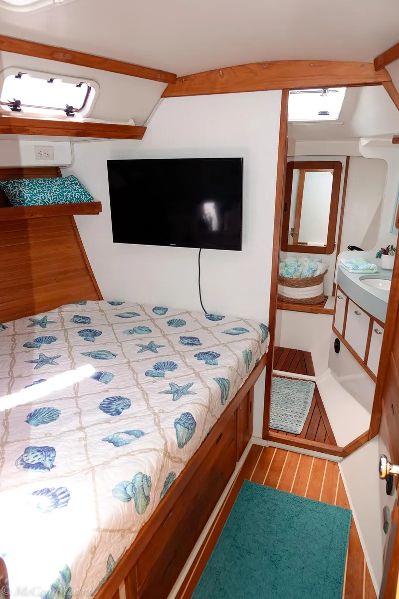 Slide: The Image of Cozy cabin interior of 1991 Catalina 42 sailboat with bed, TV, and bathroom. - 48