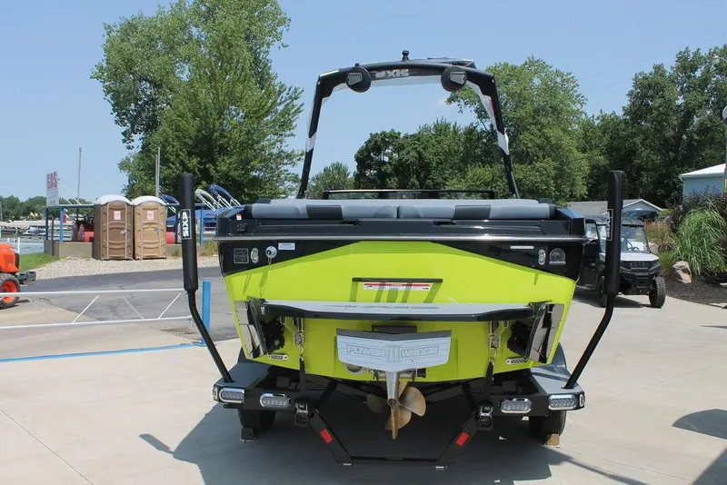 Slide: The Image of 2024 Axis T220 boat, rear view, lime green and black, on a sunny day. - 4