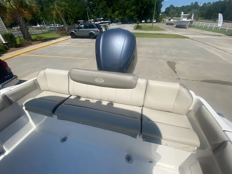 Slide: The Image of 2024 Key West 239 FS boat with rear seating and outboard motor in parking lot. - 6