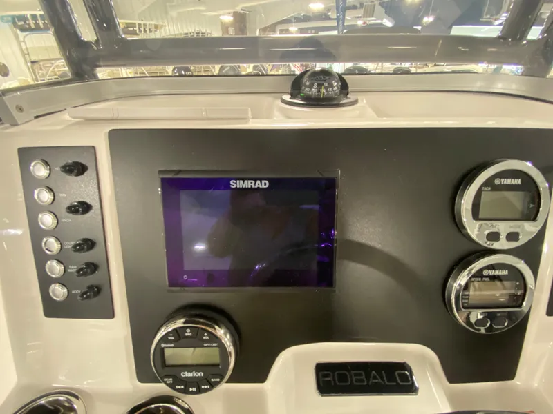 Slide: The Image of 2024 Robalo 202 Explorer boat dashboard with Simrad display and Yamaha gauges. - 12
