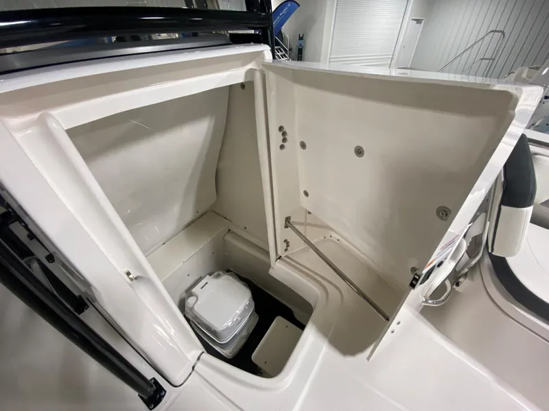 Slide: The Image of 2024 Robalo 202 EXPLORER boat storage compartment with portable toilet. - 16