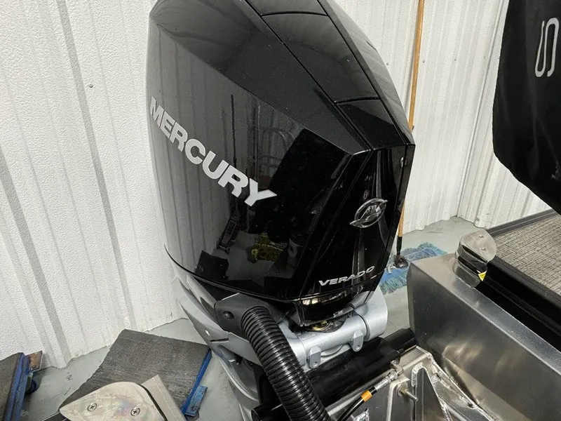 Slide: The Image of 2024 Barletta Corsa 23U with Mercury Verado outboard motor in a garage setting. - 11